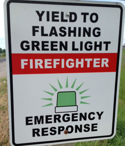 sign that says yield to flashing green light firefighter emergency response