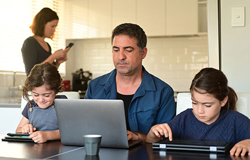 family working on different electronic devices
