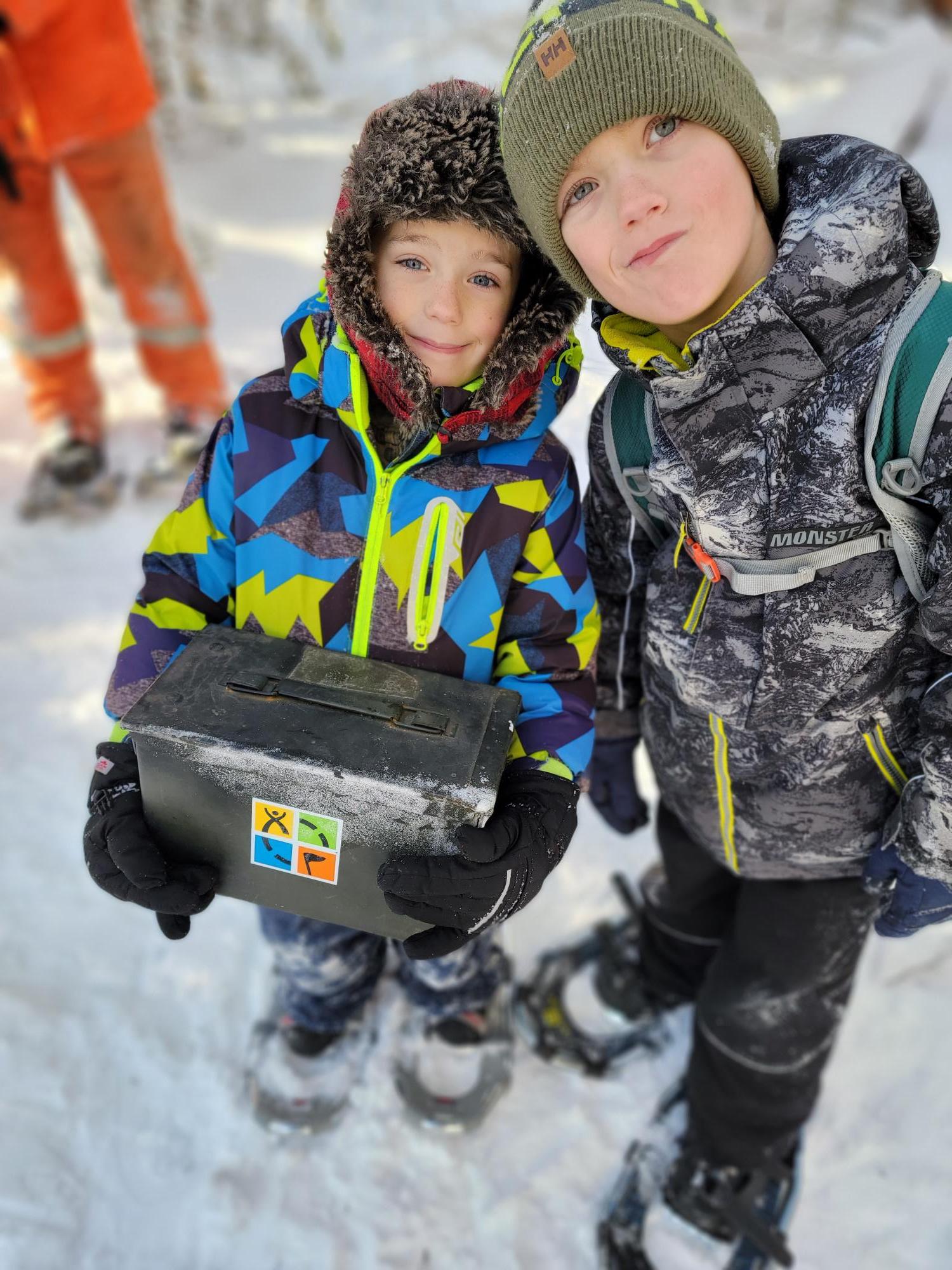 two boys hold geocache
