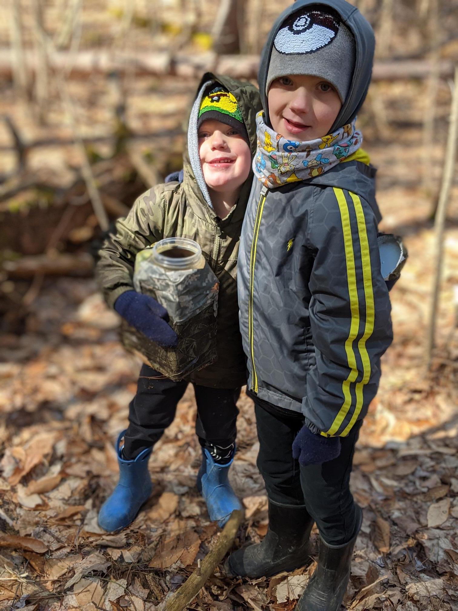 two boys holding their geocache find